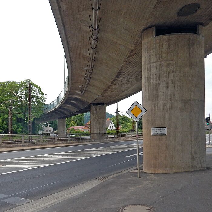 Blick auf die Konstruktion der Brücke St2435 über DB in Karlsdtadt von unten, Blick auf die Brückenstützen und die unter der Brücke befindlichen Verkehrsanlagen