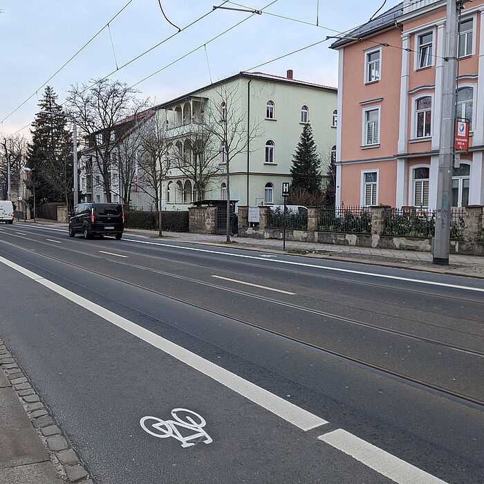 Blick auf die Fahrbahn mit Fahrzeugen mit Fahrradstreifen, von Fahrrdfahrer befahren