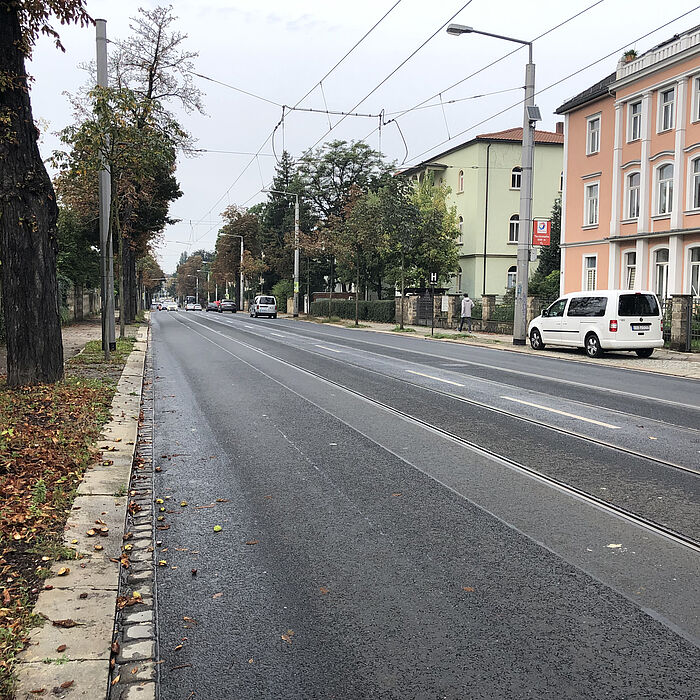 Blick auf die leere Fahrbahn, einige Fahrzeuge im Hintergrund, kein Fahrradstreifen