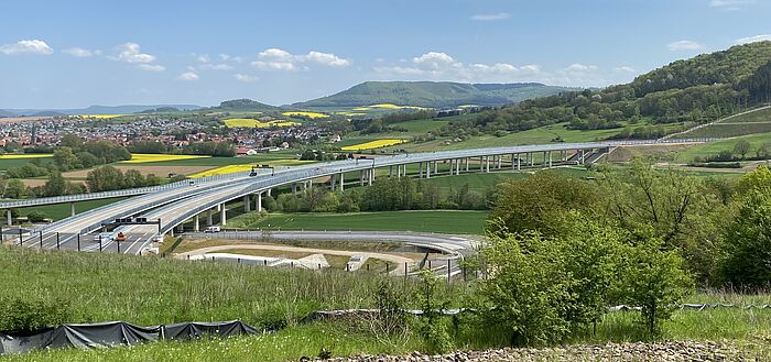 Blick von oberhalb des Tunnels auf die Wehretalbrücke, im Vordergrund Regenrückhaltebecken, im Hintergrund liegt eine Ortschaft