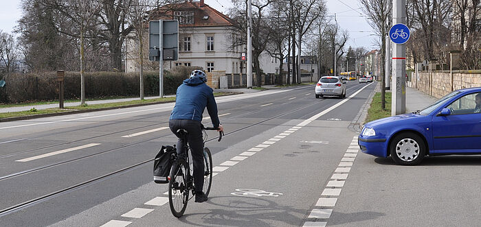 Blick auf die Bautzner Straße stadteinwärts, Fahrradfahrer befährt Fahrradstreifen, Fahrzeug wartet an einer Einmündung zum Einbiegen in die Straße