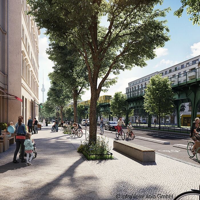 Blick auf eine belebte Straße mit Sitzbereichen auf den Gehweg, Fahrstreifen und Radfahrstreifen, U-Bahn-Viadukt, Bebauung