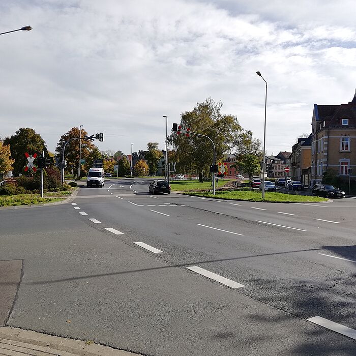 Kreuzungsbereich mit Fahrzeugen, Blick auf einen Bahnübergang