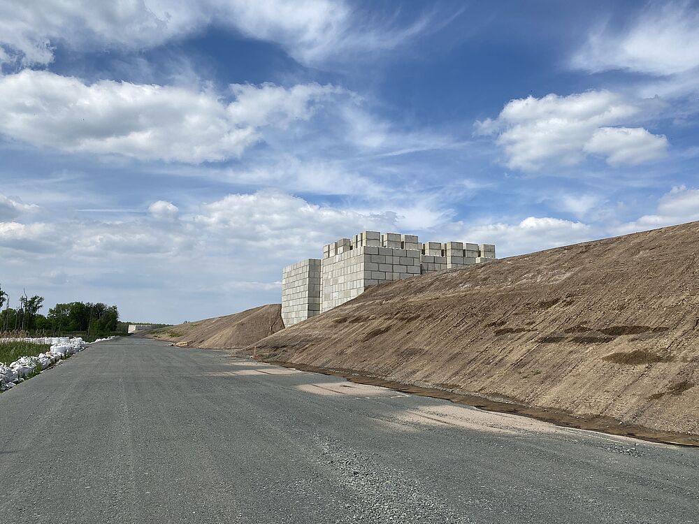 Überschüttungswall mit Belastungssteinen