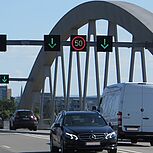 Blick direkt auf der Brücke stehend in den Verkehr, Brückenbogen im Hintergrund, über den Fahrzeugen VBA