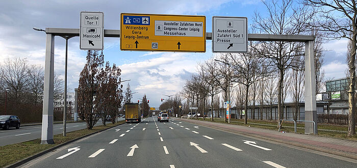 Richtungsfahrbahn mit mehreren Abbiegestreifen, darüber Schilderbrücke mit Wegweisung